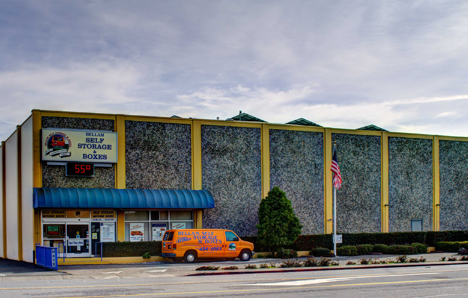 street view of storage building, sign says Bellam Self Storage and Boxes, company van parked outside entrance, overcast sky