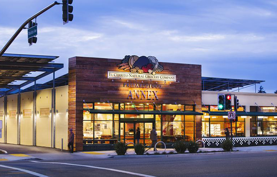 street view of El Cerrito Natural Grocery Company Prepared Food Annex, stop lights, glowing signs, evening overcast sky