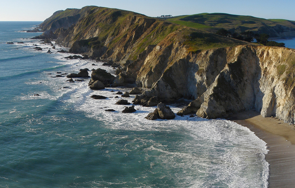 majestic overhead view of Point Reyes National Seashore, beach, ocean waves, cliffs, grassy hills, clear sky