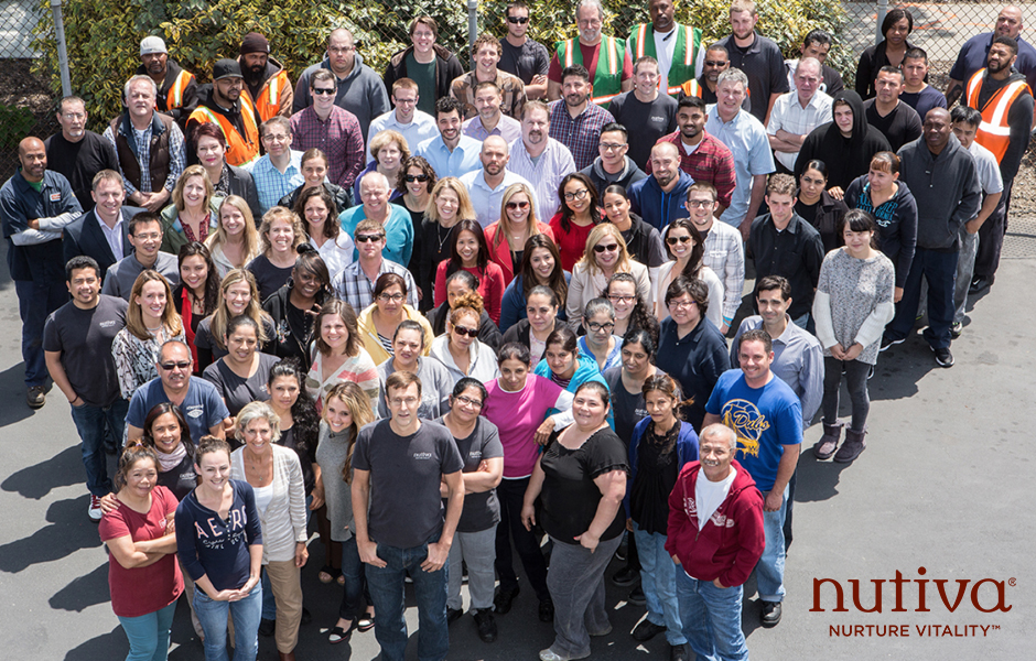 overhead view of over sixty smiling Nutiva staff members, logo on bottom right corner says Nutiva Nurture Vitality