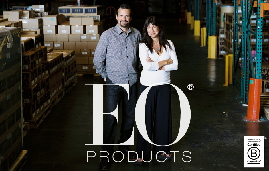 owners of business standing side by side in dimly light storage warehouse, logo says EO products