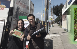 MCE Community Power Organizer, East Bay Energy Watch Business Development Manager, hold program flyer on San Pablo street