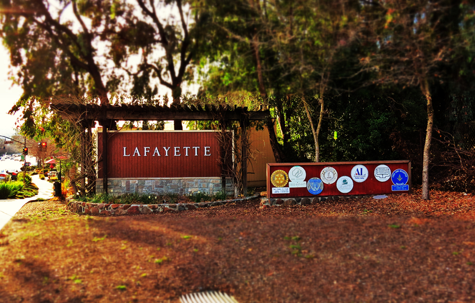 official sign to welcome drivers into city, says Lafayette, surrounded by greenery, shows seals of partner organizations