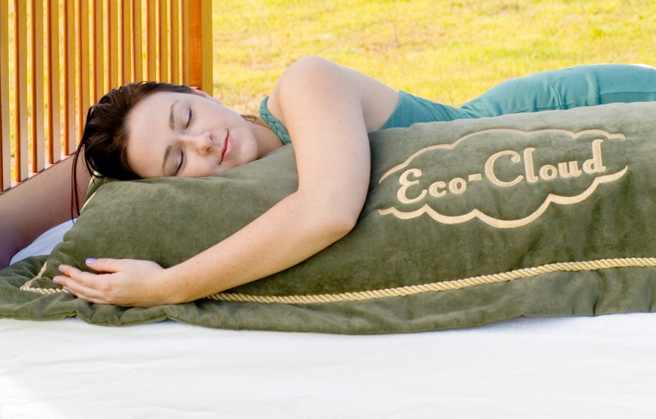 young woman sleeping on Natural Mattress bed, hugging eco-cloud, outdoors, visible grass with sunshine