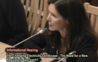 MCE CEO Dawn Weisz speaks into microphone on podium, California Sentate Energy Utilities and Communications Committee hearing