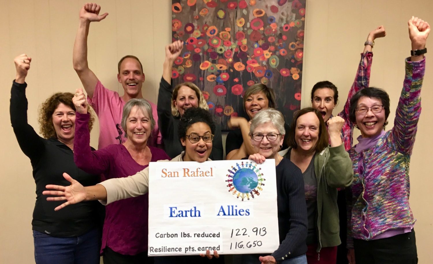 Resilient Neighborhoods member group celebrating together with sign that reads Earth Allies